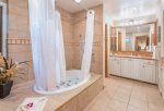 The master bathroom features a large soaking tub and two vanities with sinks